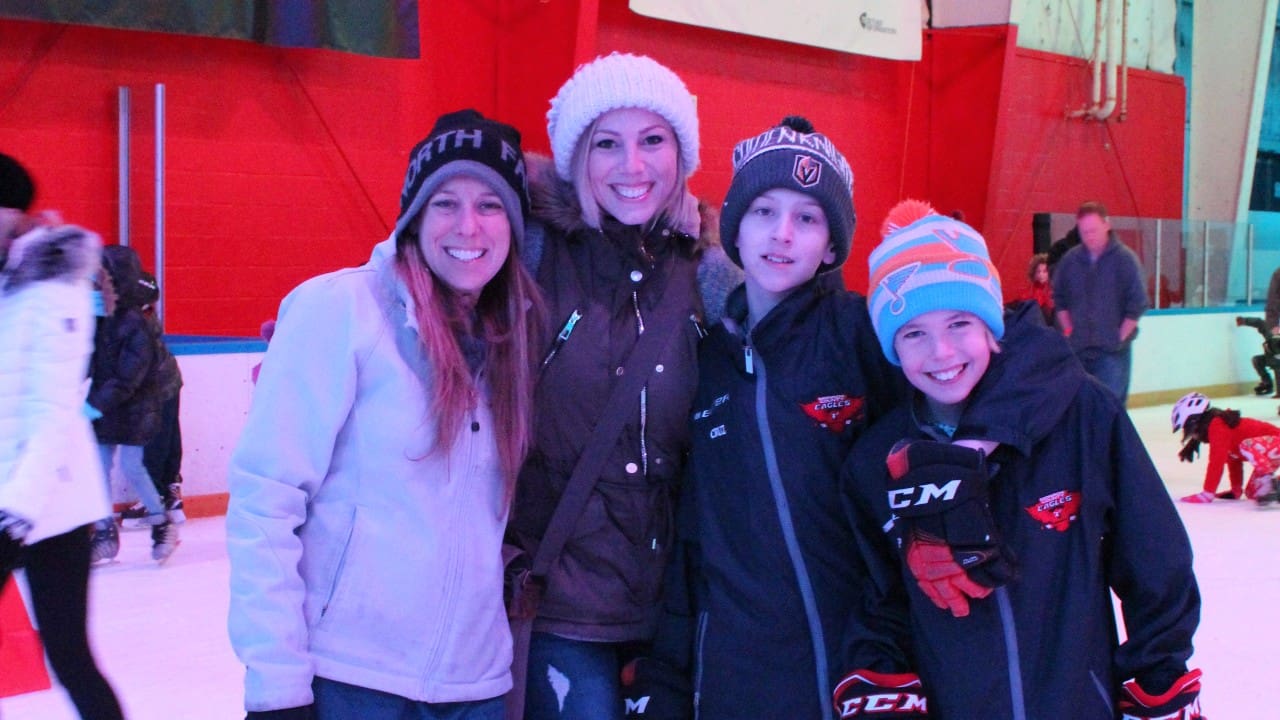 Family posing and smiling on the ice during a fun Public Skate session