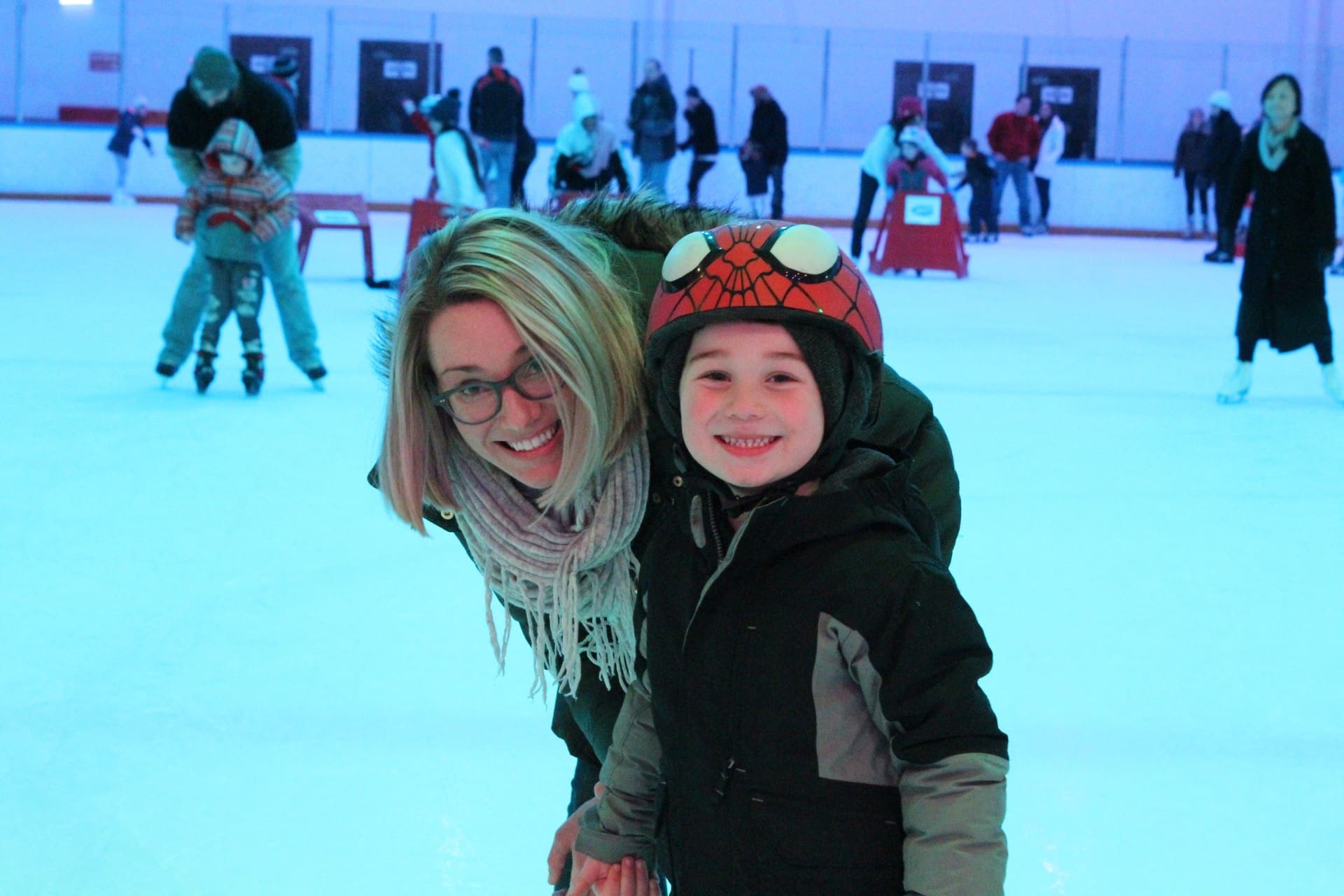 Mother and young child posing together on the ice, enjoying Public Ice Skating time